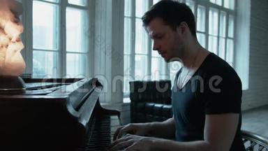 一个穿T恤的帅哥在对面的窗户上弹钢琴.. 钢琴上有一盏红灯。 这就是